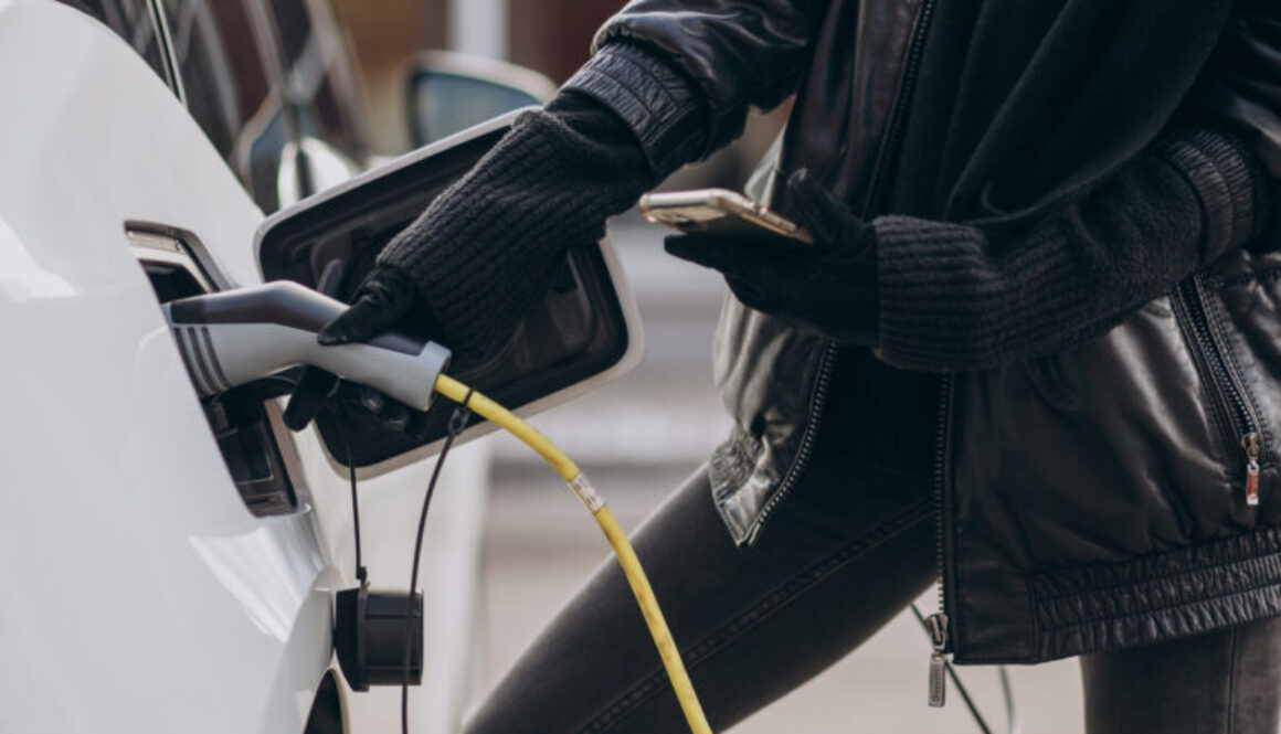 Woman charging electro car at the street