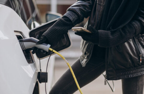 Woman charging electro car at the street
